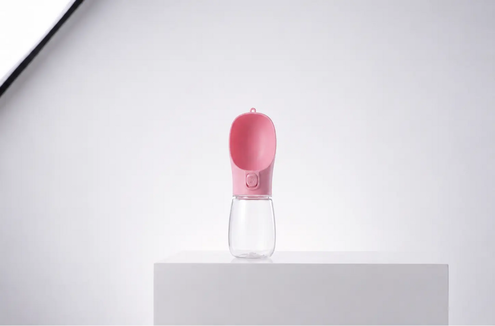 Pink portable dog water bottle with built-in drinking bowl