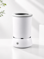A white Portable Dog Paw Cleaner with a power button on the front base, set on a clean white surface with soft shadows.